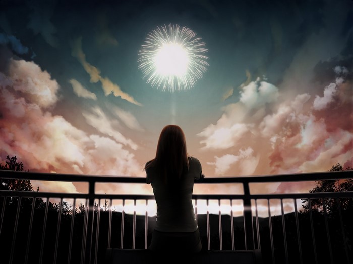 Girl watching fireworks from a balcony
