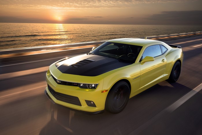 Yellow 2014 Chevrolet Camaro 1LE driving by the ocean at sunset