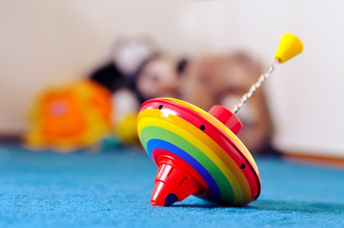 Rainbow spinning top toy on blue surface