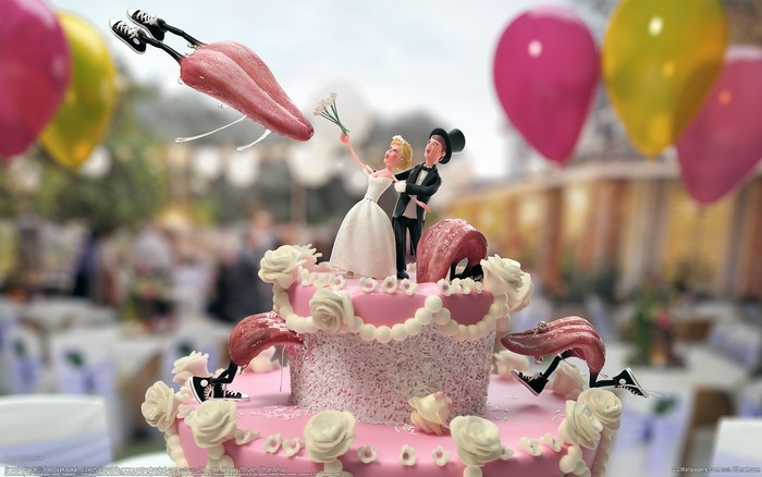 Wedding cake with bride and groom figurines and tongues