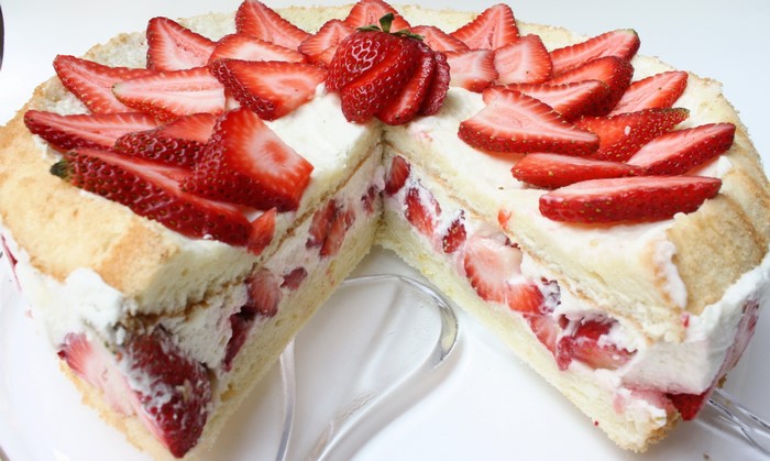 Strawberry cake with cream and sliced strawberries