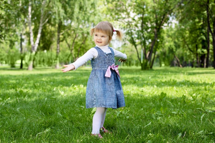 Little girl in denim dress in a park