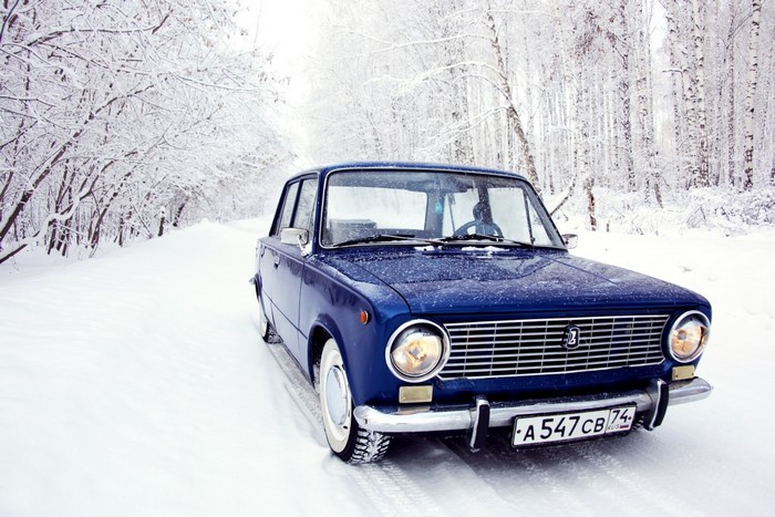 Blue VAZ-2101 car in a snowy forest