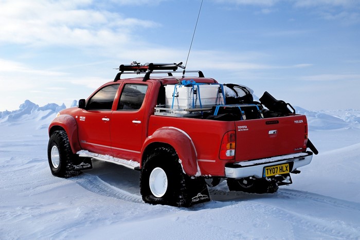 Red Toyota Hilux Arctic Trucks in Snowy Landscape