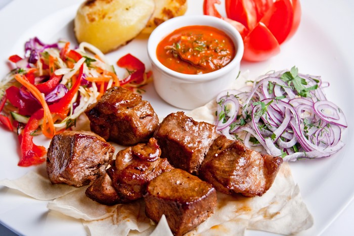 Shashlik with potatoes, salad, and sauce
