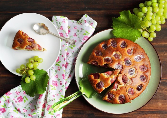 Grape cake on a plate with a slice on another plate