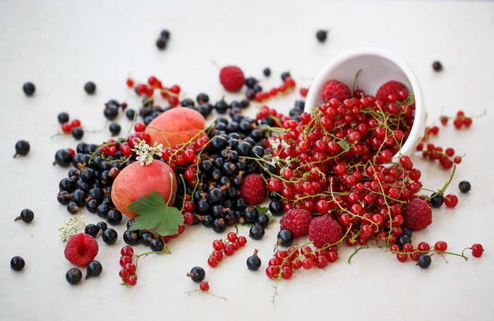 Fresh Berries and Apricots Spilled from a Bowl