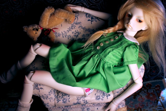 Doll in a green dress with a teddy bear