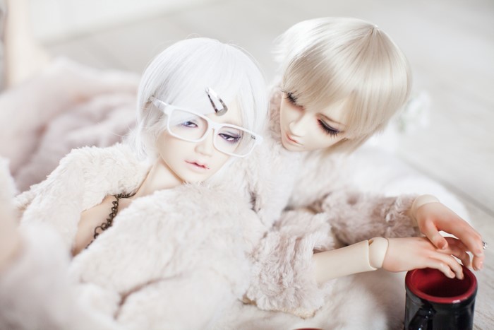Two dolls with white hair and glasses