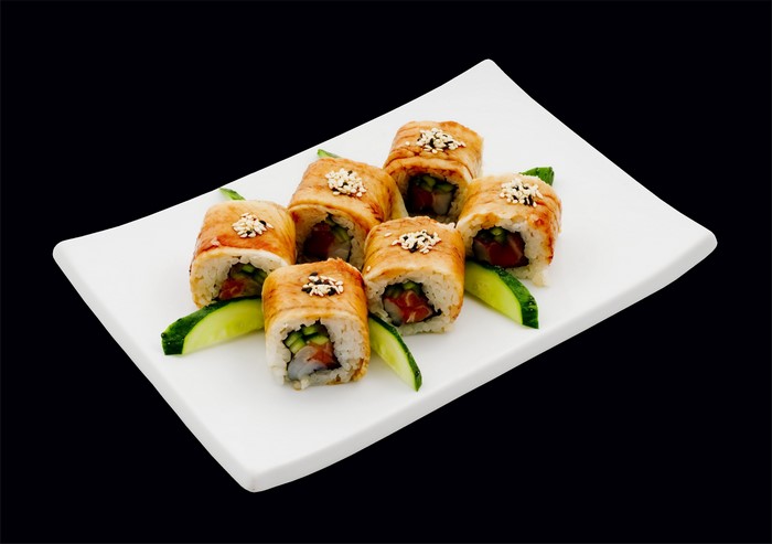 Sushi rolls with eel and cucumber on a white plate