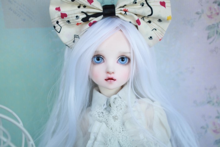 Doll with white hair and blue eyes wearing a bowknot