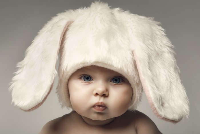 Baby wearing a white bunny hat