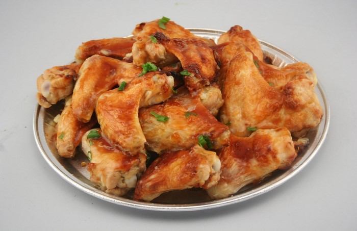 Plate of glazed chicken wings with chives