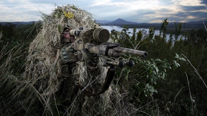 Camouflaged Sniper Aiming with Telescopic Rifle