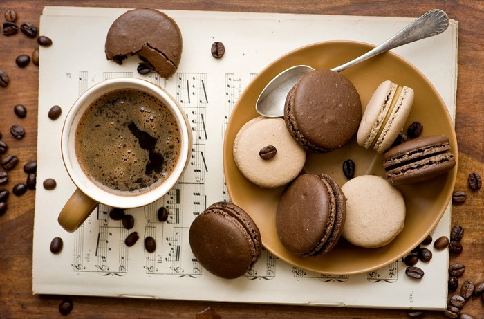 Coffee cup and macarons on sheet music