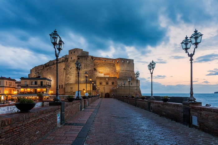 Castel dell'Ovo fortress with street lights at dusk