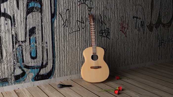 Acoustic guitar leaning against a graffiti-covered wall with roses and a microphone