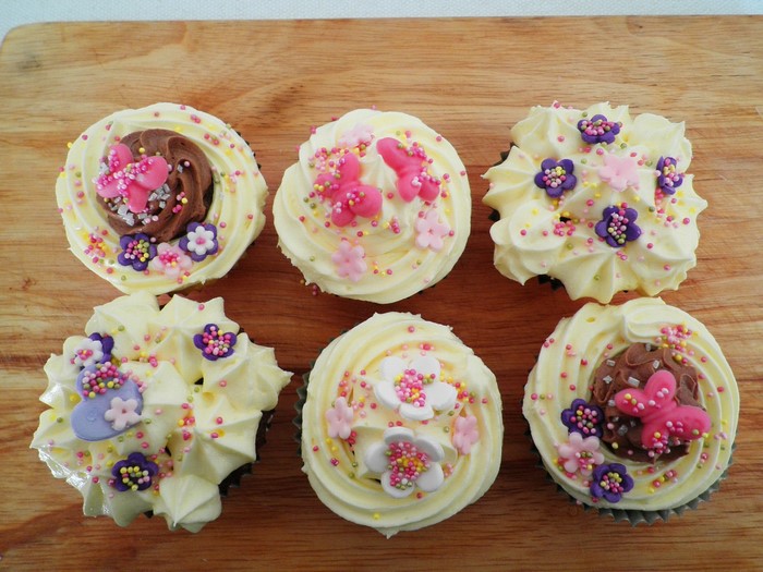 Six decorated cupcakes with frosting and sprinkles