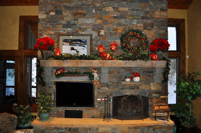 Christmas decorated fireplace with poinsettias and wreath