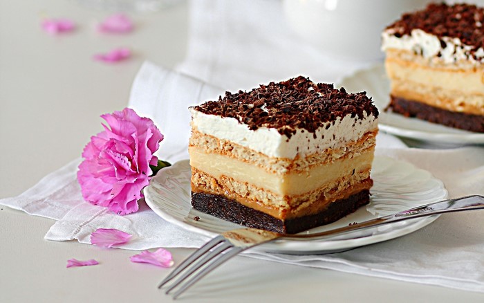 Layered chocolate cake with whipped cream and chocolate shavings