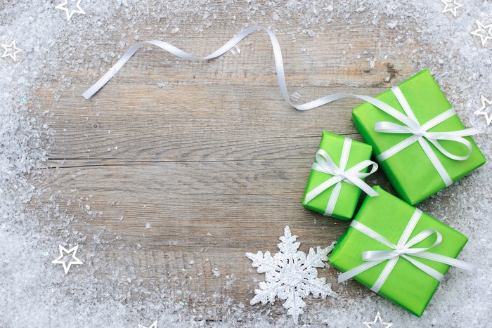 Christmas Gifts with Snow and Ribbon on Wood