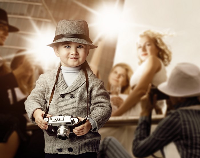 Boy with camera and hat at a photoshoot