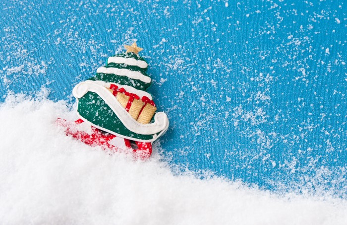 Christmas tree in a sleigh with gifts in snow