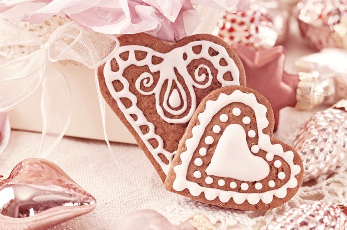 Heart-shaped gingerbread cookies with white icing and Christmas ornaments