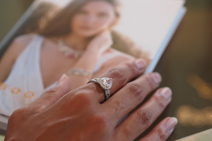 Hand with engagement ring on a magazine