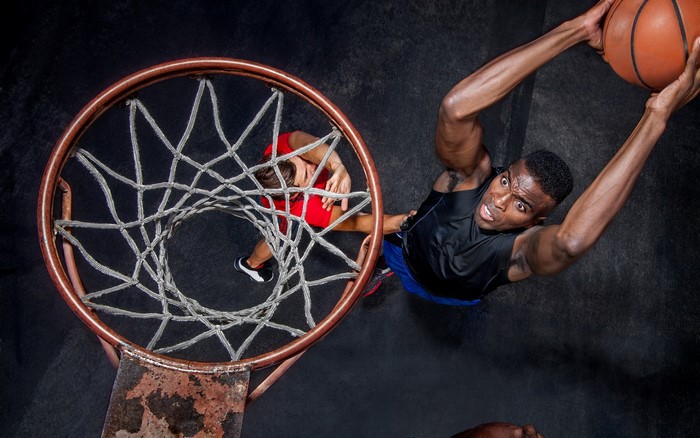 Basketball players dunking and defending