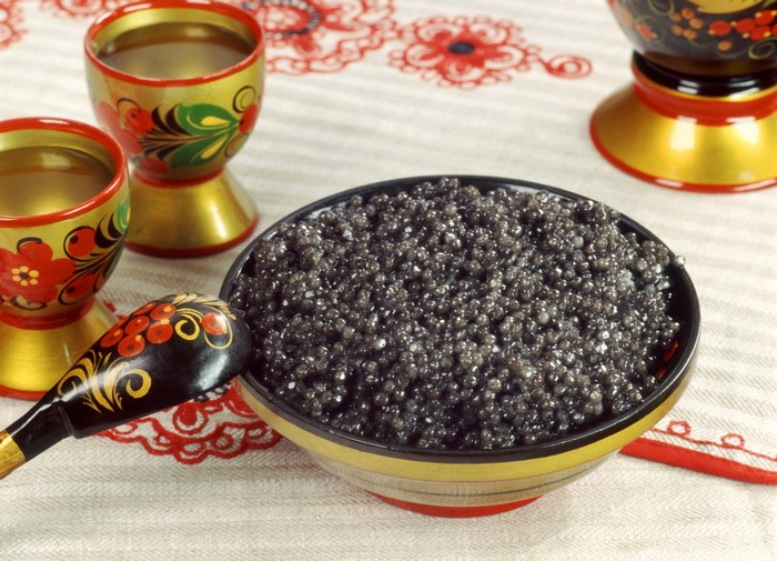 Black Caviar in a Bowl with Russian Nesting Dolls and Spoon