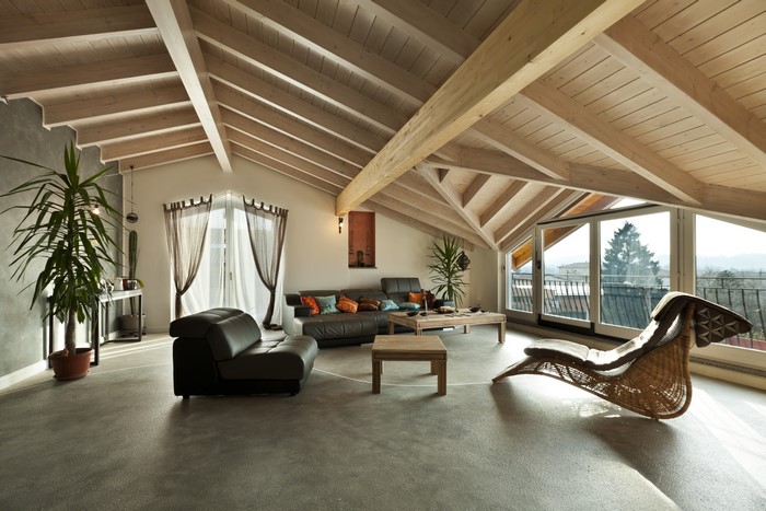 Attic living room with exposed beams and large windows