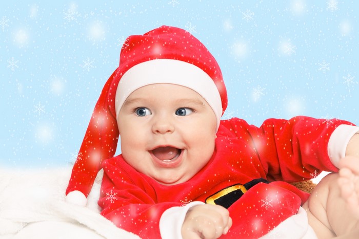Baby in Santa hat and costume with snowflakes