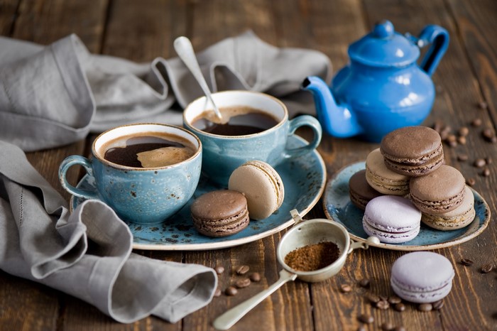 Coffee cups and macarons on a wooden table
