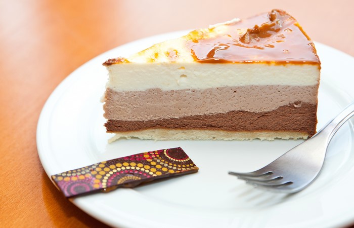 Slice of triple chocolate mousse cake with caramel