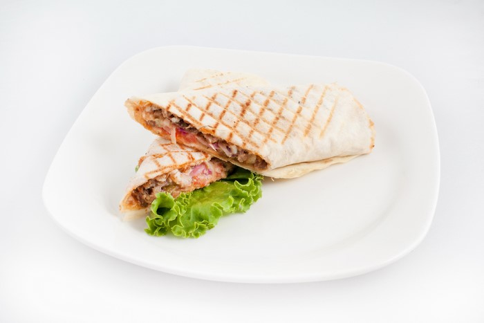 Shawarma on a white plate with lettuce