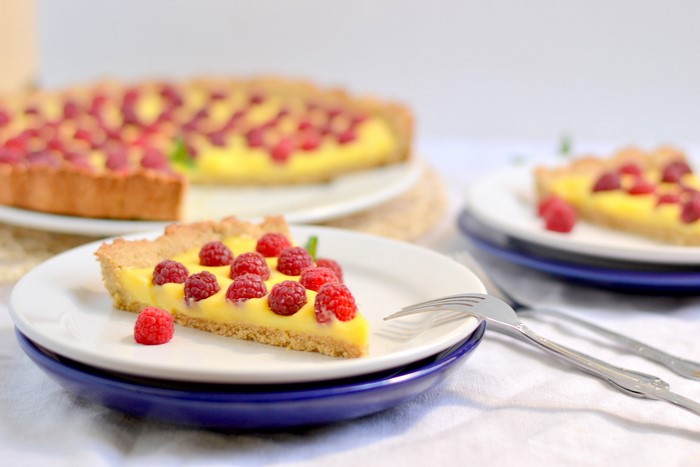Raspberry tart with custard on plates