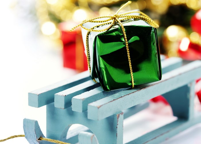Green gift on a blue sled with Christmas decorations