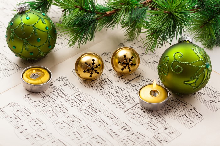 Christmas Ornaments, Bells, Candles, and Pine on Sheet Music