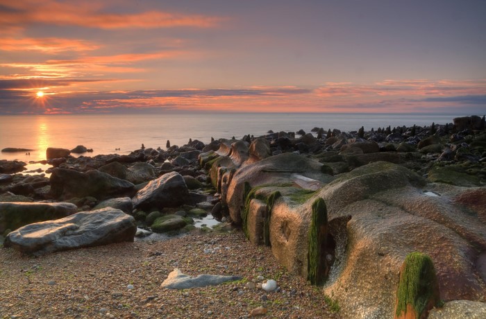 Sunrise over a rocky coast with the sea