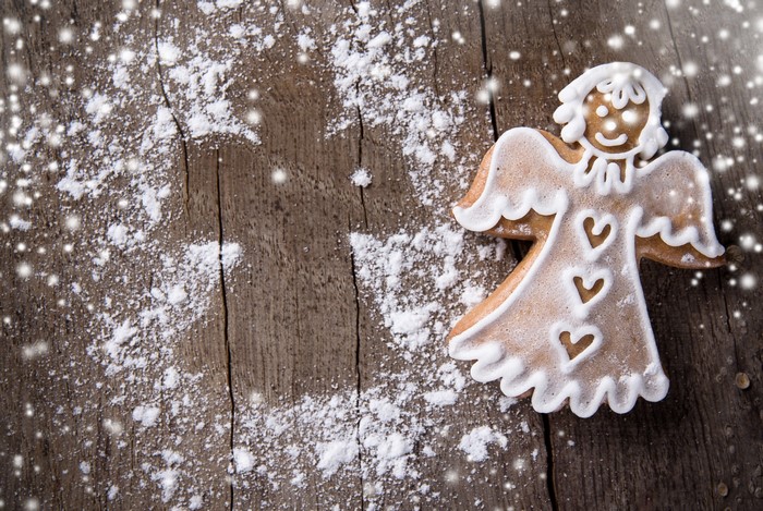 Gingerbread angel cookie with powdered sugar and snow