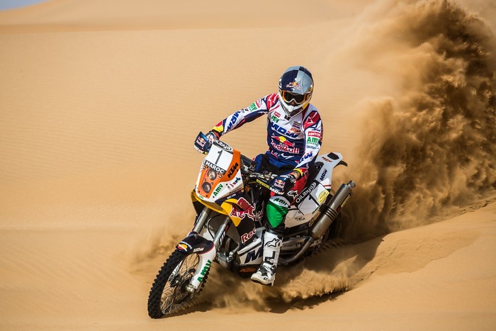 Motorcyclist racing through desert sand