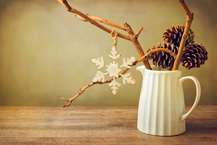 Pine cones and snowflake ornament in a jug