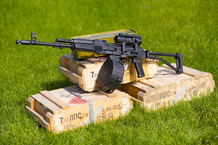 Assault rifle with drum magazine on ammunition crates
