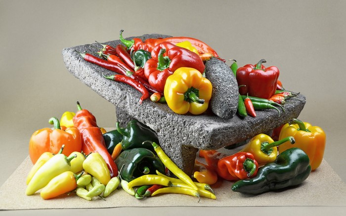 Assortment of colorful peppers and chilies in a stone molcajete