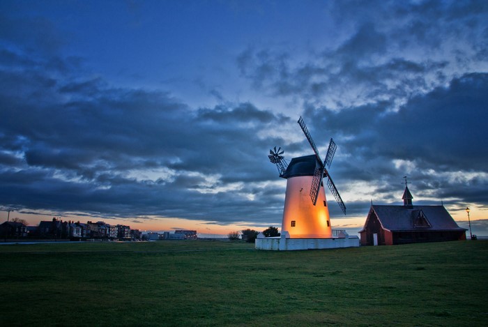 Windmill and church at sunset with clouds