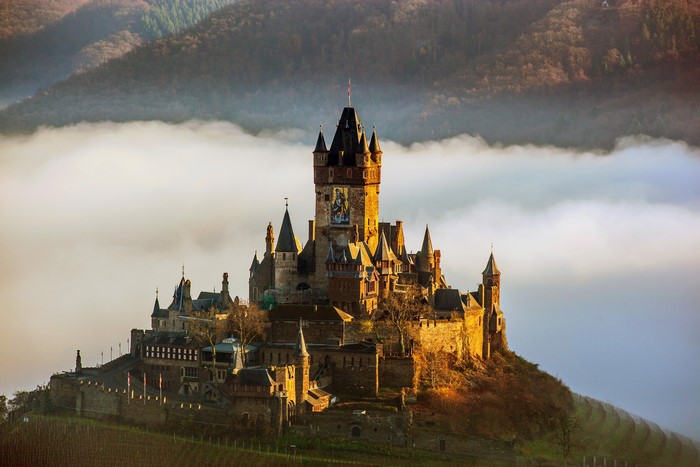 Reichsburg Cochem Castle above fog in Germany