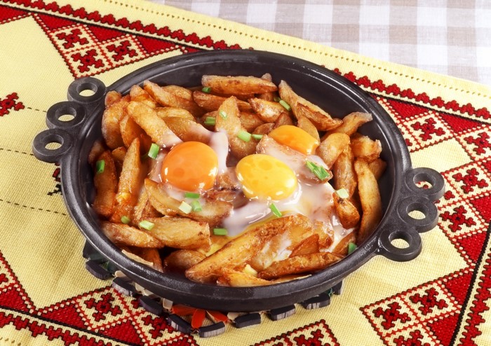 Fried potatoes with eggs in a pan