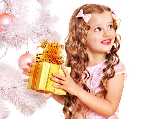 Little girl with Christmas gift and tree