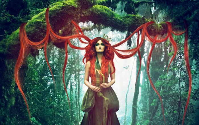 Redhead woman with flowing hair in a magical forest